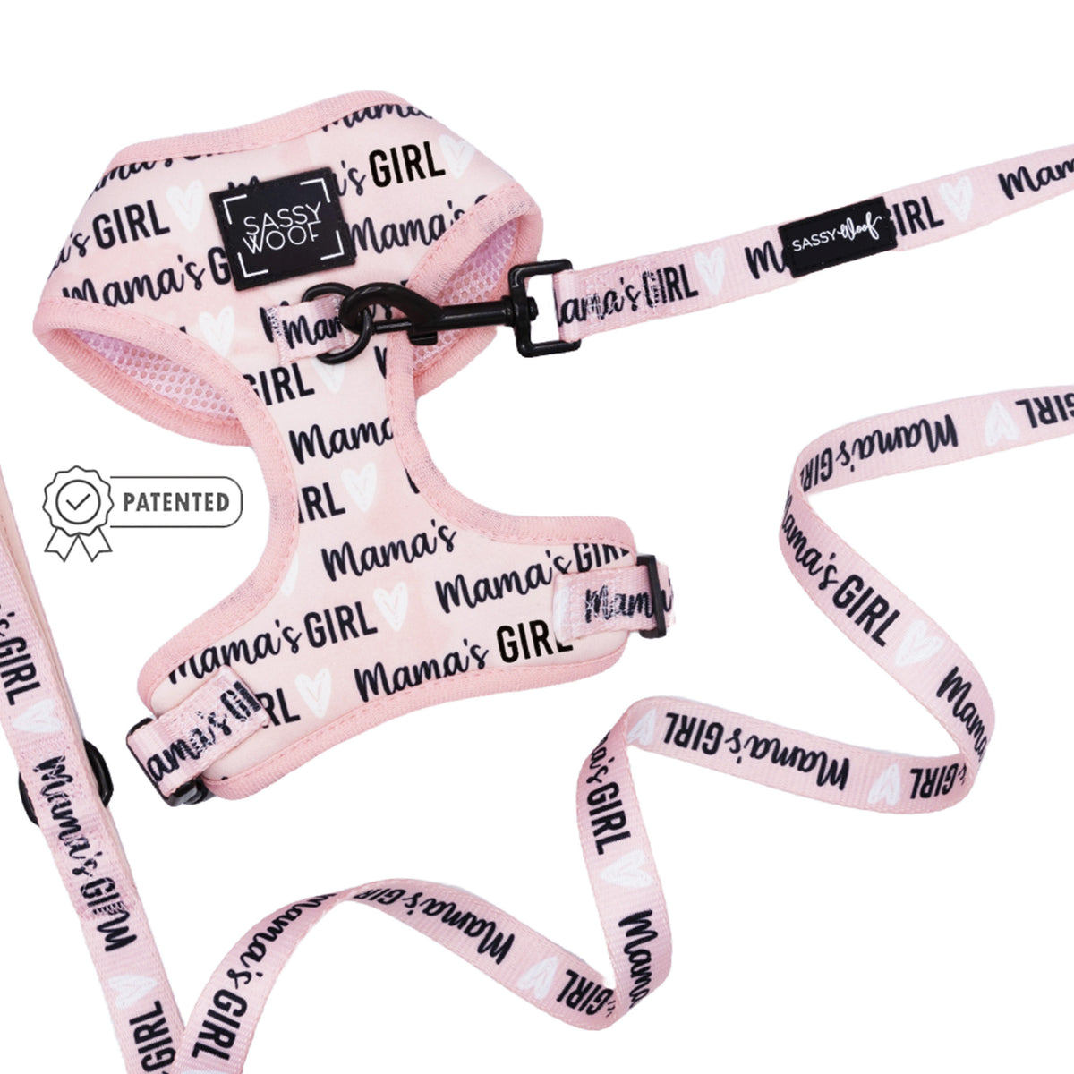 The Sassy Woof Dog Two Piece Bundle - Mama's Girl includes a pink adjustable harness with black "Mamas GIRL" text and white hearts, plus a matching leash. Features Sassy Woof branding and patented badge for comfort as your puppy grows.