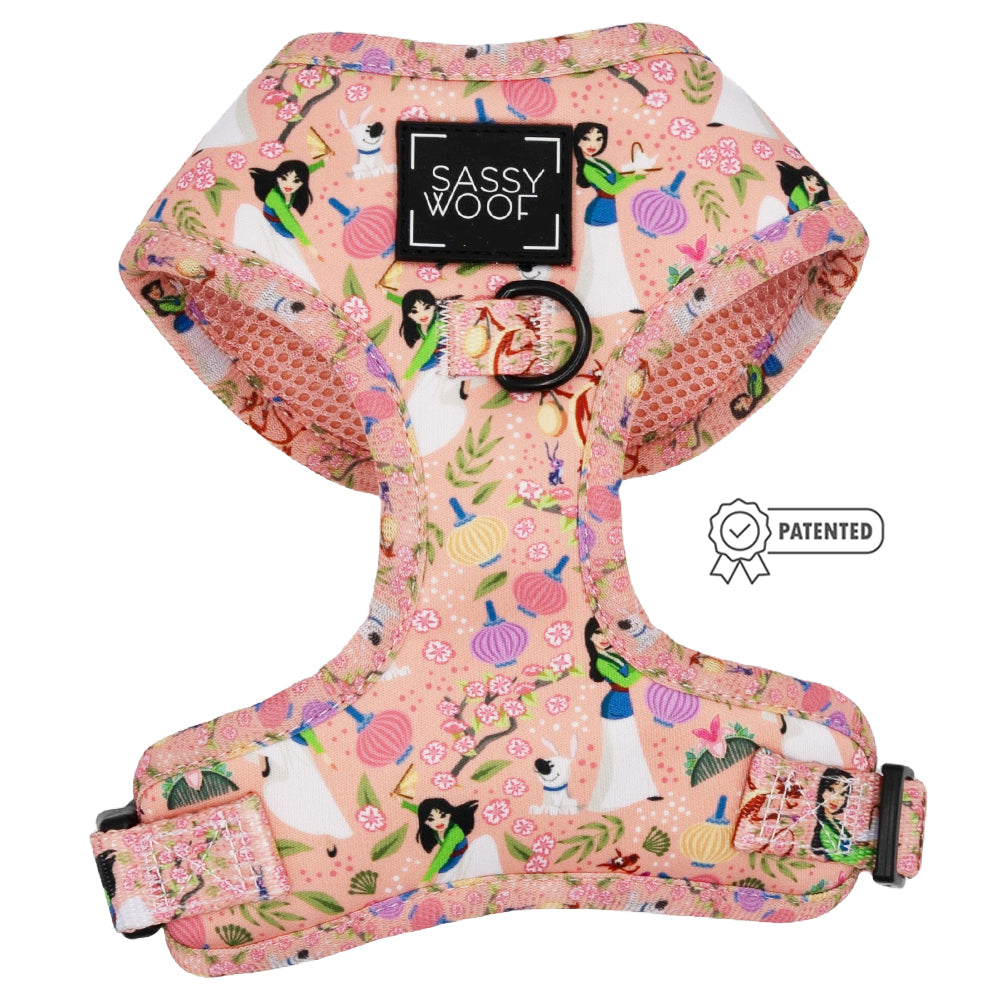 The Sassy Woof Dog Two Piece Bundle – Disney's Mulan is a pink adjustable harness with princess, pumpkin, and floral prints, black metal ring, adjustable straps, PATENTED badge nearby, and Puppy Growth Pawtection Plan support.