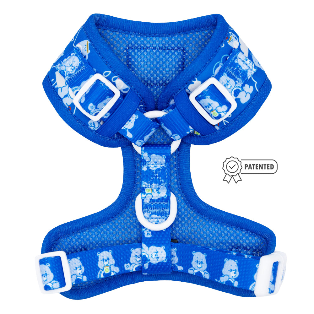 The Sassy Woof Dog Adjustable Harness - Care Bears™ Grumpy Bear is a blue harness with white buckles and straps, cartoon bear designs, and a Patented badge graphic on the right side.