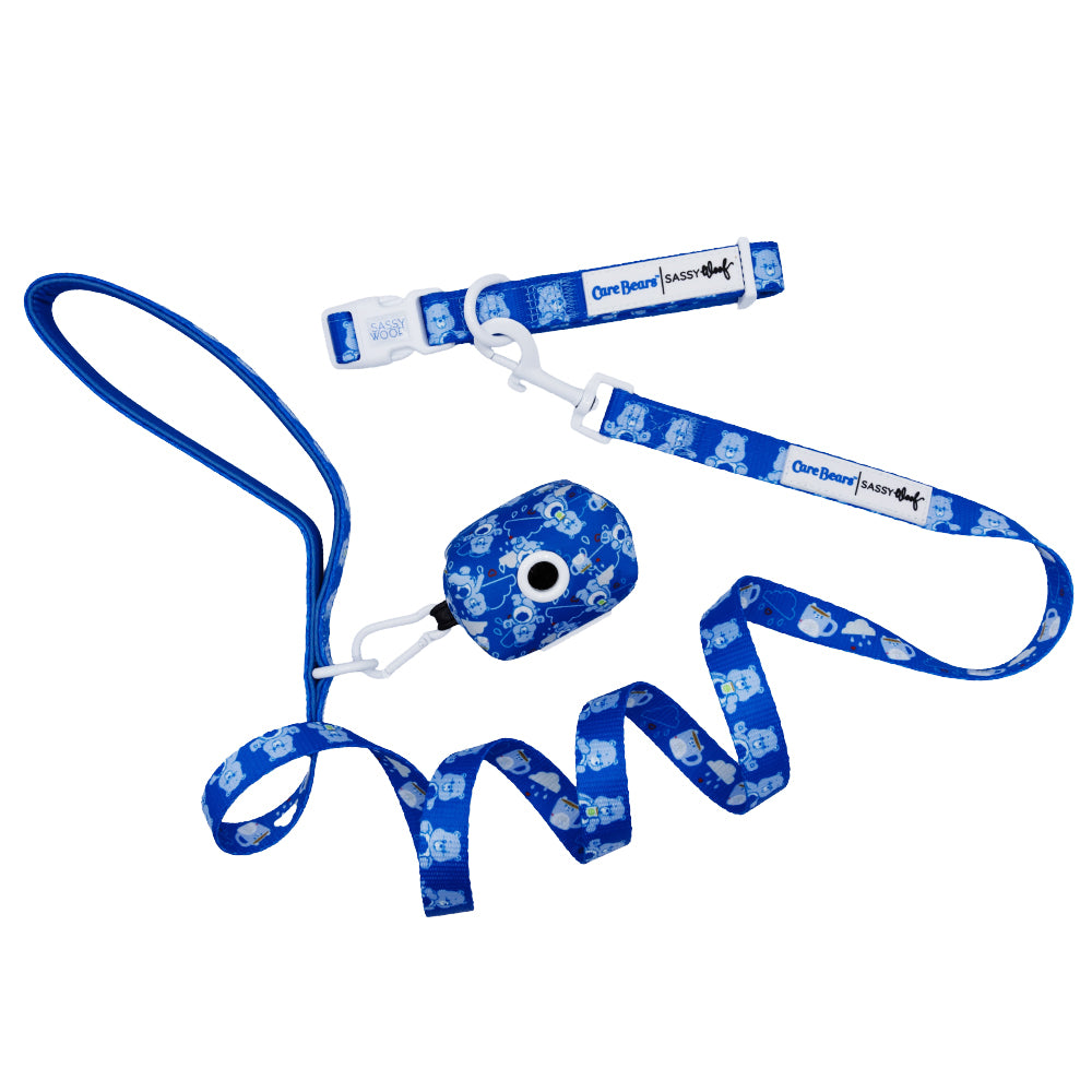 The Sassy Woof Collar Three Piece Bundle - Care Bears™ Grumpy Bear includes a blue collar with cartoon dog patterns, plastic buckle, brand label, matching leash, and waste bag holder—perfect to pair with other Grumpy Bear pet accessories.