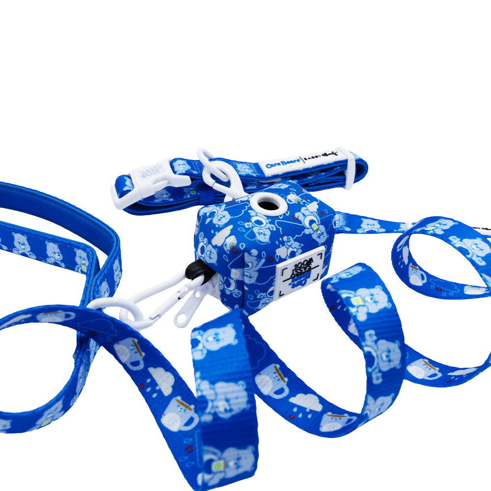 The Sassy Woof Collar Three Piece Bundle - Care Bears™ Grumpy Bear features a blue retractable leash with a cute bear pattern, white clips, and matching handle, shown on a white background.