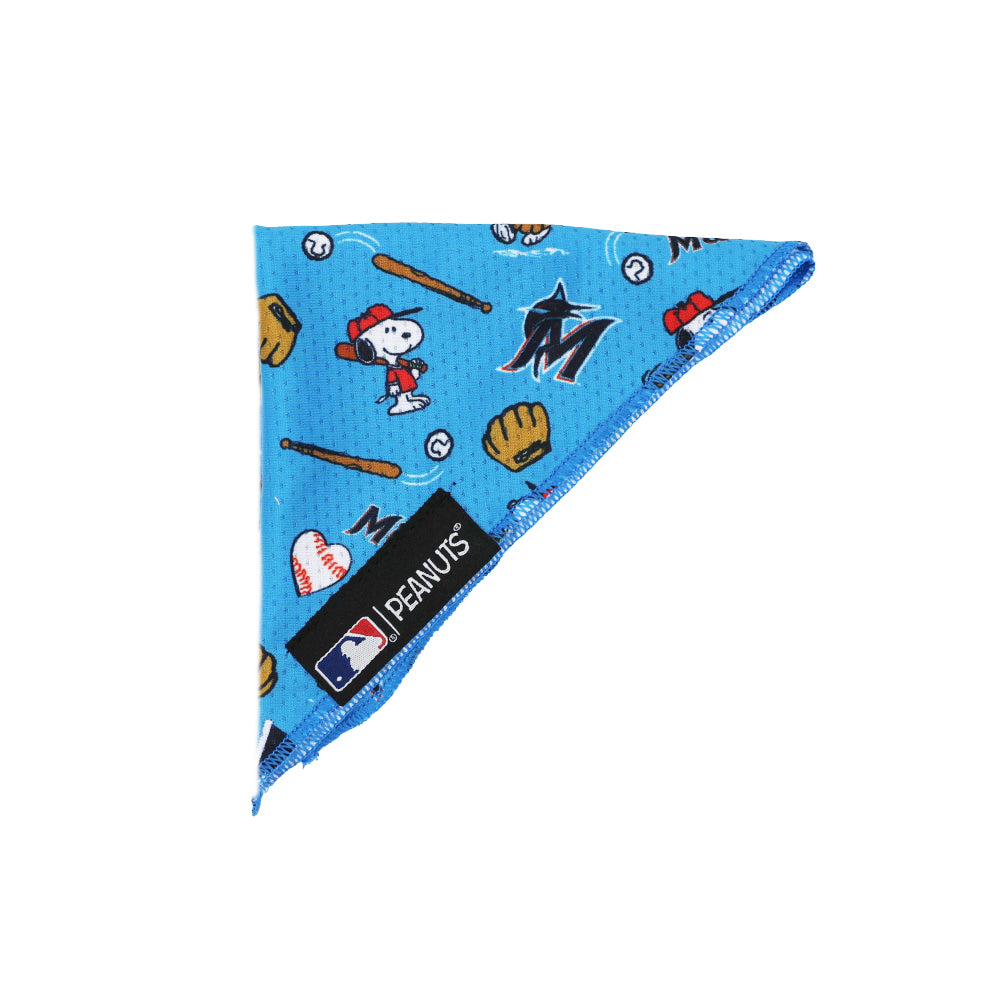 The Sassy Woof Dog Bandana - MLB™ x Peanuts™ Miami Marlins™ is a blue bandana with Snoopy baseball motifs, baseballs, gloves, and bats, plus a black label featuring the Peanuts™ and MLB™ logos.