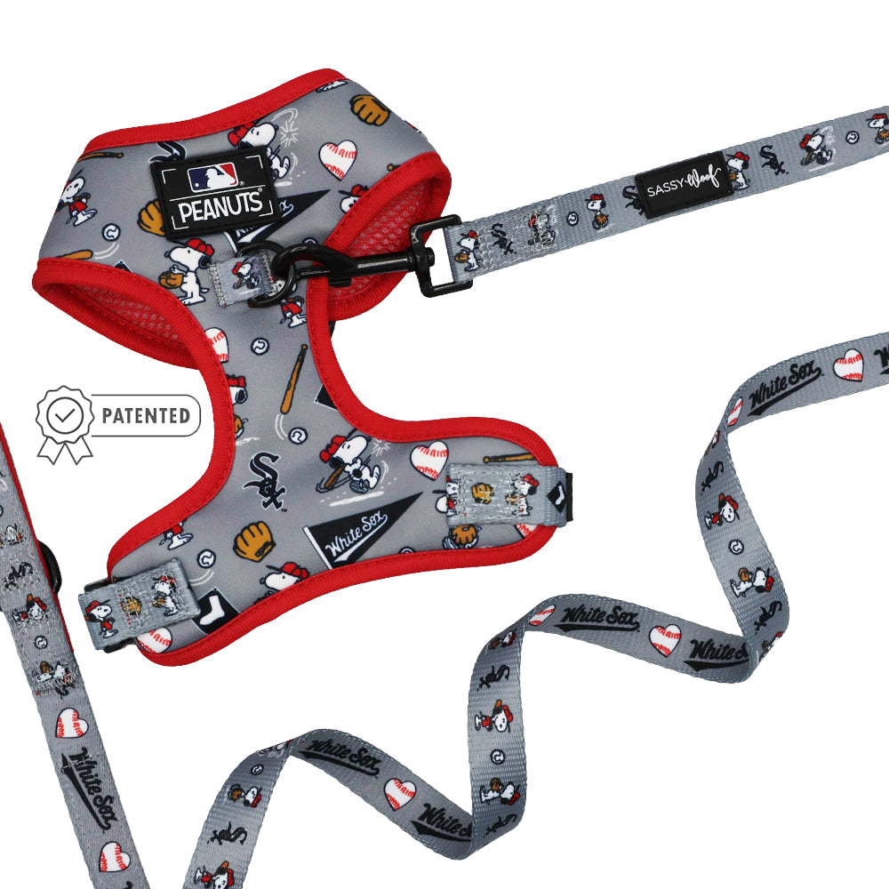 The Sassy Woof Dog Two Piece Bundle - MLB™ x Peanuts™ Chicago White Sox™ features a gray Snoopy harness and baseball leash with red trim, Snoopy and baseball graphics, a “PATENTED” badge, and the Sassy Woof label.