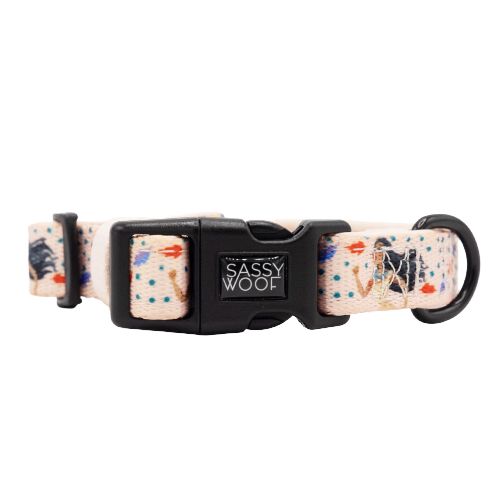 The Sassy Woof Dog Collar - Disney's Pocahontas features playful dog illustrations in pink with colorful spots, a black plastic buckle, and sturdy D-ring—add enchantment to every walk with this adorable adjustable collar.