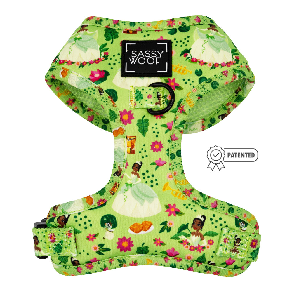 The Sassy Woof Dog Adjustable Harness – Disney’s Tiana features bright green fabric with Princess Tiana, flowers, and frogs. This harness includes an adjustable fit, metal leash ring, patented symbol, and Sassy Woof branding.