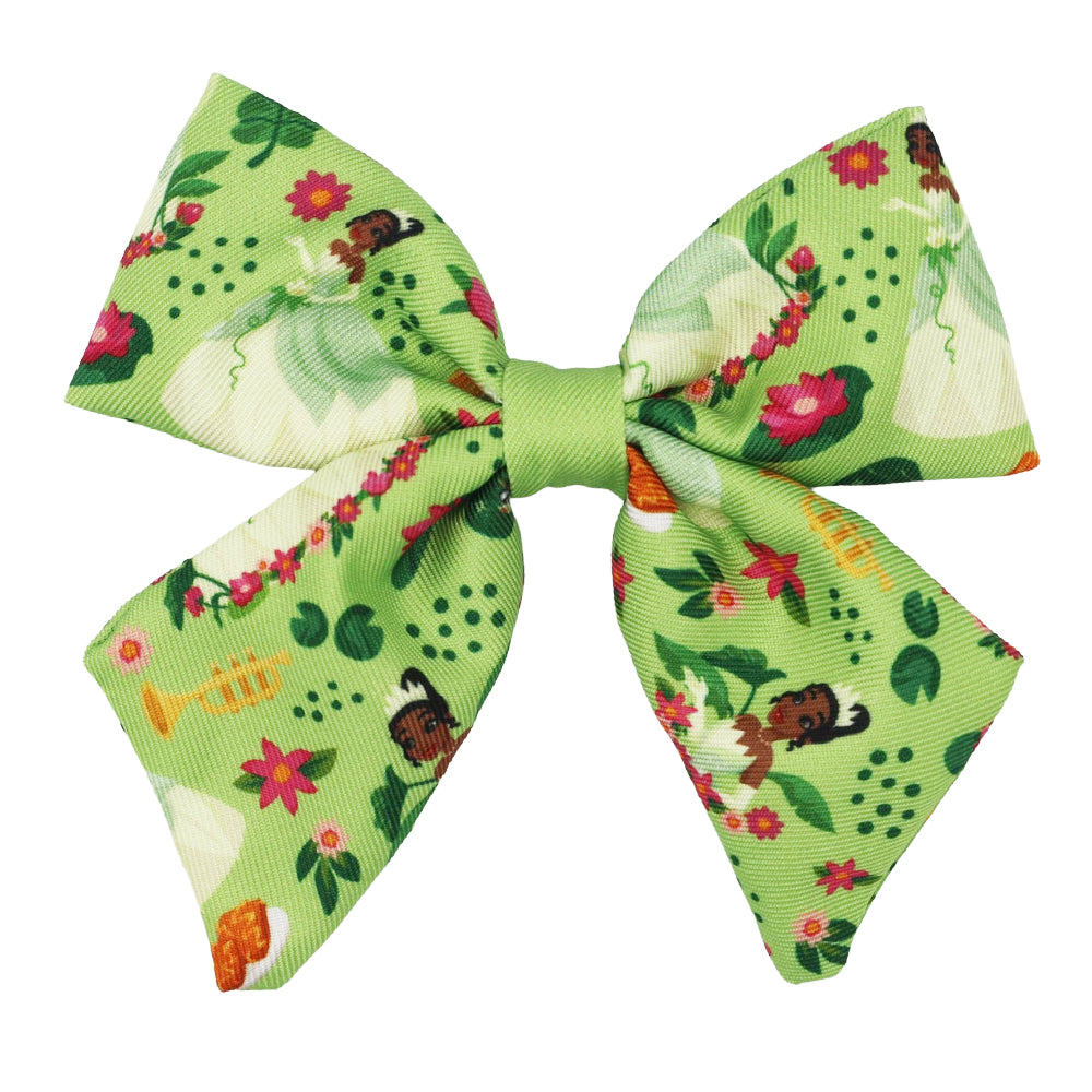 The Sassy Woof Dog Sailor Bow - Disney's Tiana features vibrant pink, yellow, and red floral patterns with cartoon princesses on a light green background—an ideal match for your Princess and the Frog dog harness.