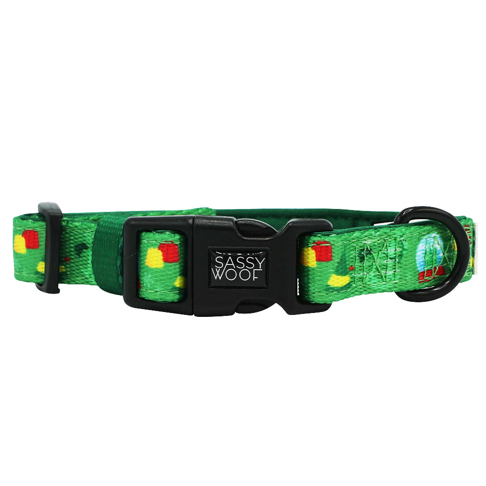 The Dog Collar - Elf™ by Sassy Woof is a green neoprene adjustable collar, featuring colorful food illustrations, a black plastic buckle, and a sturdy black metal ring for leash attachment.