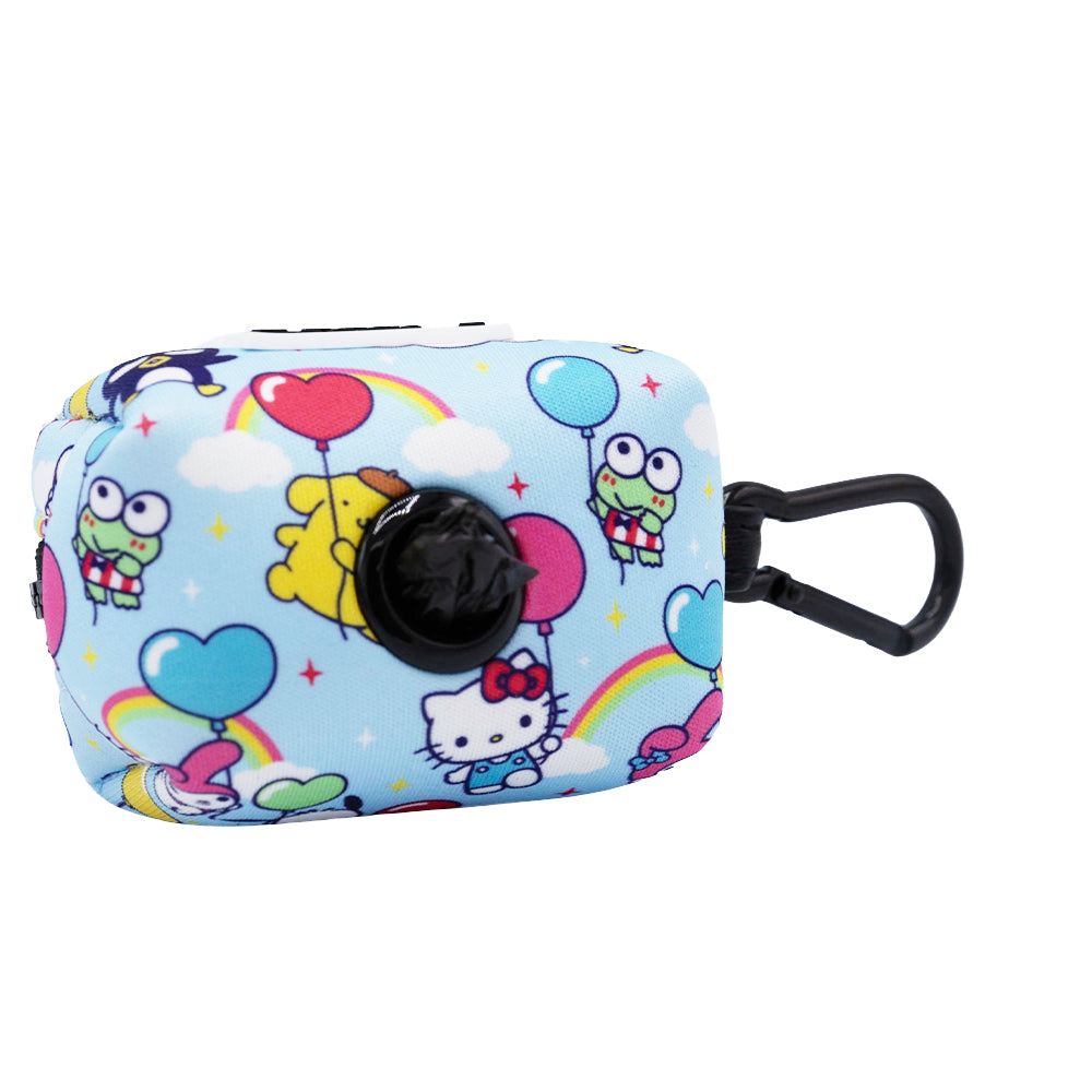 The Sassy Woof Dog Waste Bag Holder - Hello Kitty® & Friends In the Sky is a small, rectangular light blue pouch with colorful cartoon designs, a black plastic clip, and a circular opening for dispensing bags.