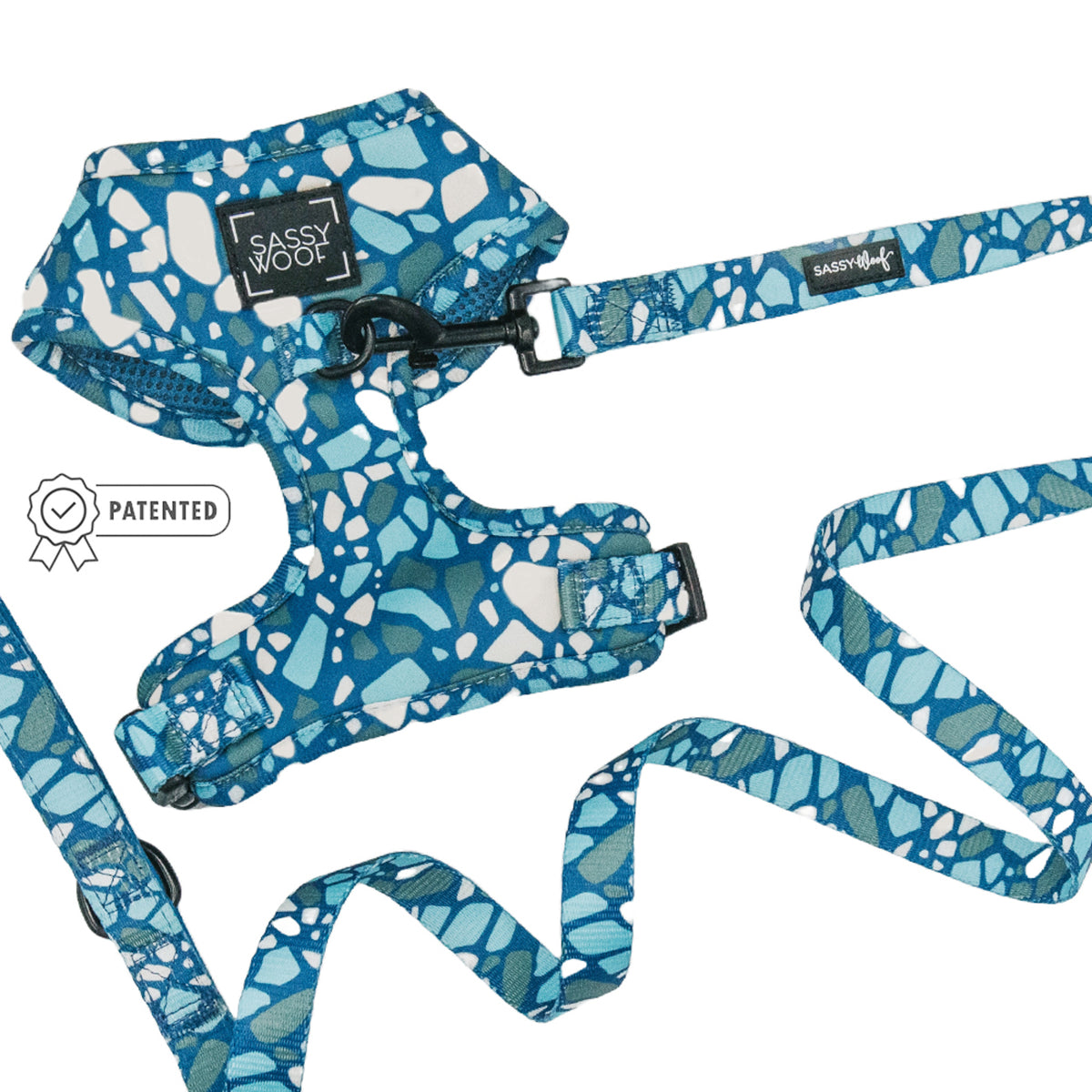 The Sassy Woof Dog Two Piece Bundle - Santorini, featuring an adjustable blue and white patterned harness with a matching leash, is displayed on a white background alongside a “Patented” icon.