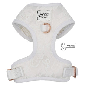 The Sassy Woof Dog Adjustable Harness - Pup of Honor features white satin and lace, rose gold hardware, a Sassy Woof chest label, an adjustable fit, and a PATENTED badge on the right side.