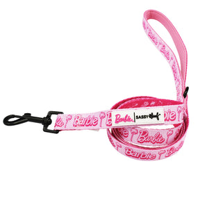 The Sassy Woof Dog Leash - BARBIE™ Malibu is a pink leash with "Barbie" and palm tree graphics, a black metal clasp, and a branded label near the handle.