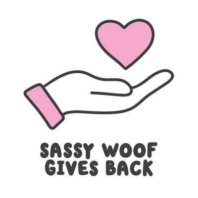 Icon displaying a hand with a heart above and text below reading "Sassy Woof Gives Back"