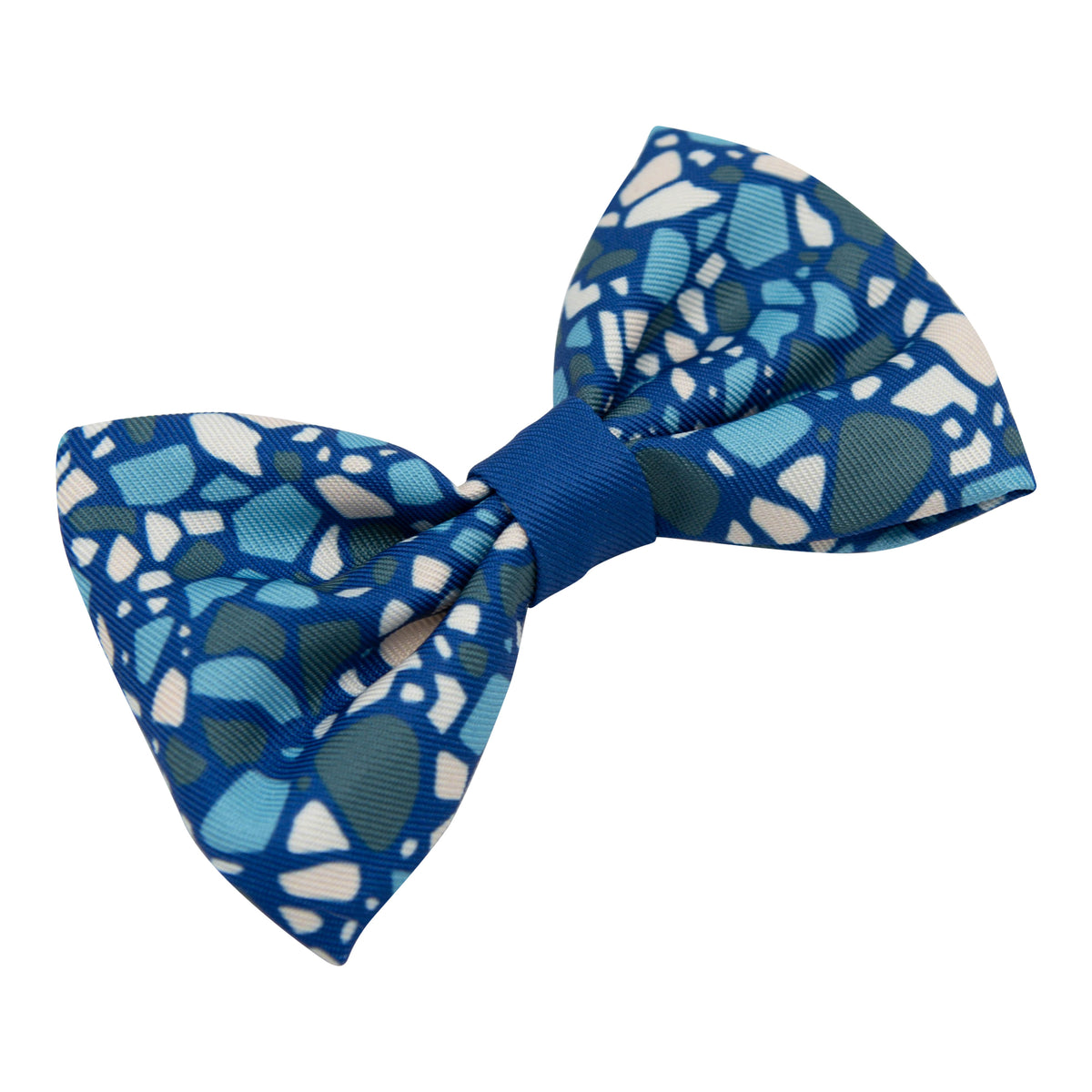 The Sassy Woof Dog Bowtie - Santorini features a vibrant blue mosaic pattern in shades of blue, white, and green, and is perfect for pairing with a matching leash or adjustable harness for a coordinated style.