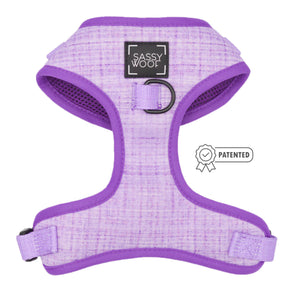 The Sassy Woof Dog Adjustable Harness - Aurora features a lavender color with purple trim, a black Sassy Woof logo patch, an attached metal ring, and a Patented badge displayed on the side.