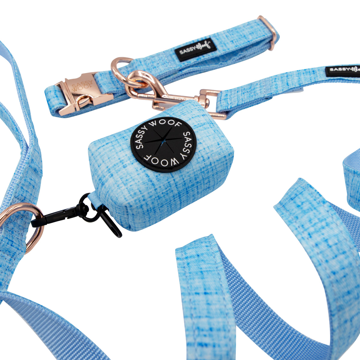 The Sassy Woof Collar Three Piece Bundle - Blumond features a light blue dog collar, leash, and matching waste bag holder with rose gold hardware, displayed against a white background.