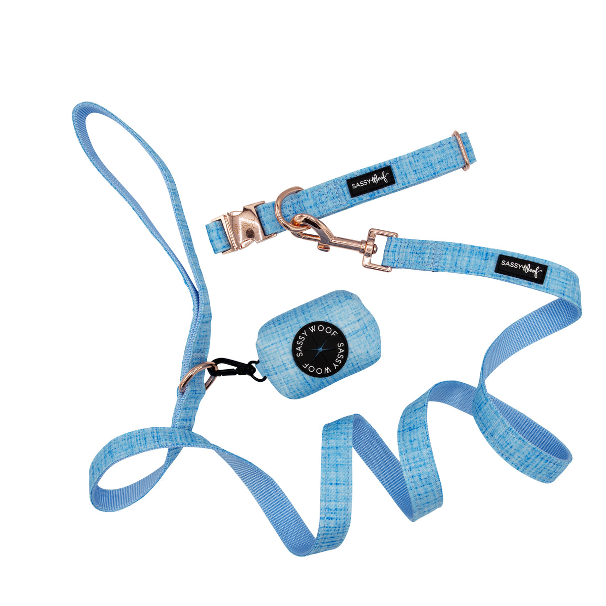 The Sassy Woof Collar Three Piece Bundle - Blumond features a blue textured dog leash and matching collar with gold hardware and black Sassy Woof tag, plus an attached waste bag holder. All items are shown on a white background.