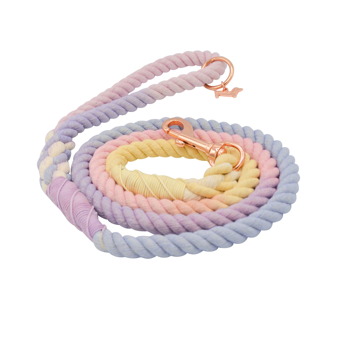 The Sassy Woof Dog Rope Leash - Caroline features hand-crafted, pastel twisted ombre rope in purple, yellow, and pink, rose gold hardware, and a clip for easy collar attachment. Coiled spiral design.