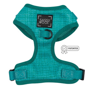 The Dog Adjustable Harness - Napa by Sassy Woof is a teal, no-pull harness with a textured pattern, black D-ring, adjustable straps, and a patent badge displayed beside its stylish design.