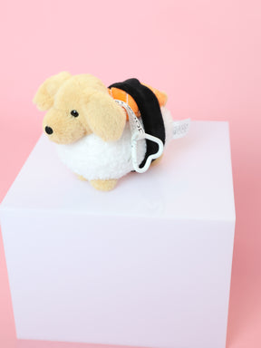 A Sassy Woof Blind Box collectible stuffed dog in a black and orange outfit sits on a white cube with a pink background.