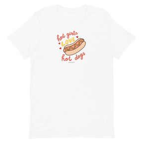 The Sassy Woof Hot Girls Love Hot Dogs Tee is a white unisex t-shirt with a fun hot dog graphic and playful “hot girls love hot dogs” text in red and orange, printed using eco-friendly ink.