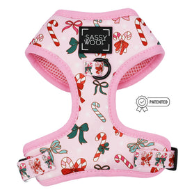 The Dog Adjustable Harness - Candy Cane Coquette by Sassy Woof features a pink festive design with candy canes, bows, and holly. This adjustable harness showcases a patented badge icon and cheerful holiday charm on the front.
