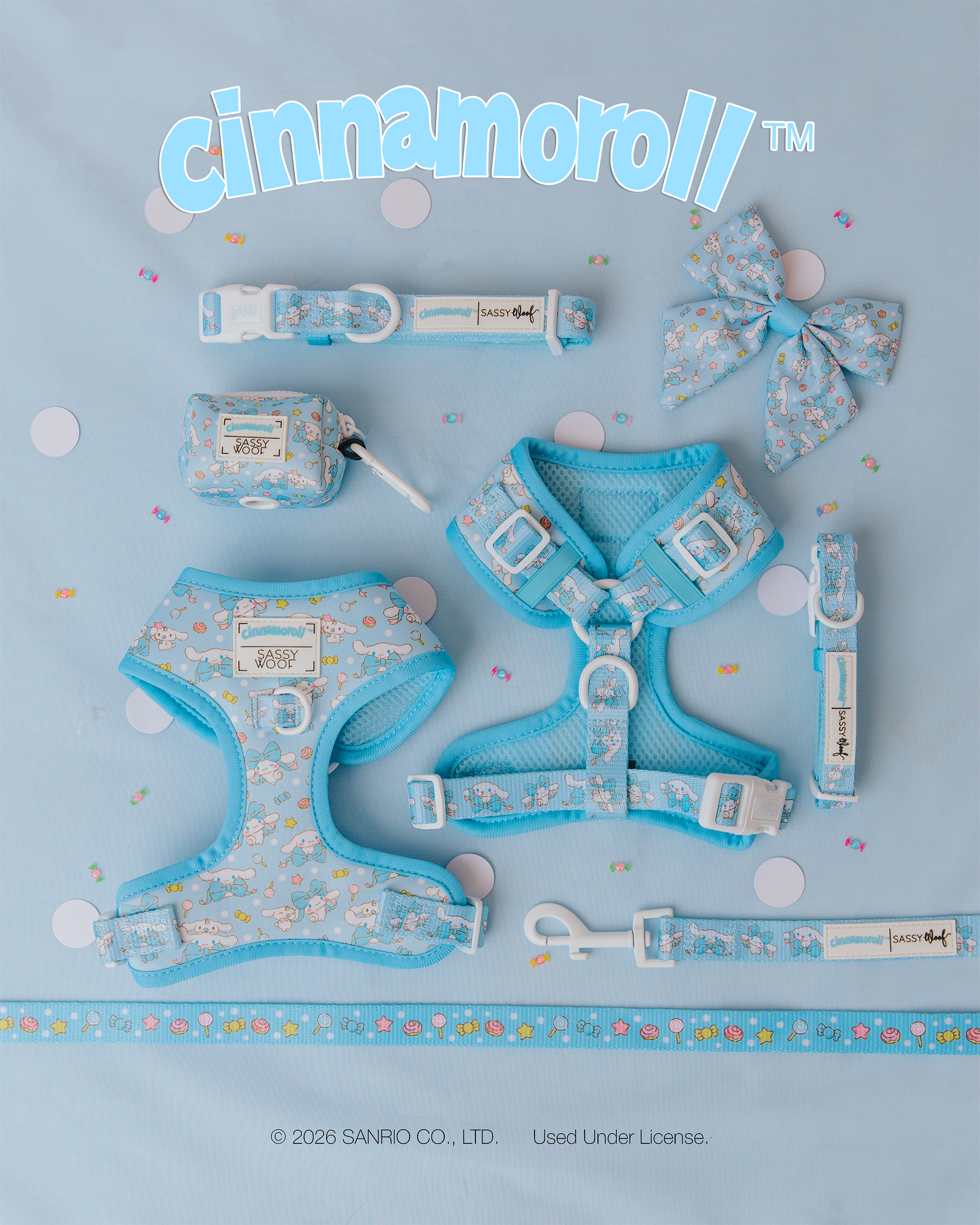 Sassy Woof’s Dog Adjustable Harness - Cinnamoroll™, collars, leash, bow, pouch, and measuring tape are neatly displayed on a confetti-decorated light blue surface featuring cute cartoon character patterns.