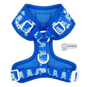 The Sassy Woof Dog Adjustable Harness - Care Bears™ Grumpy Bear is a blue harness with white buckles and straps, cartoon bear designs, and a Patented badge graphic on the right side.