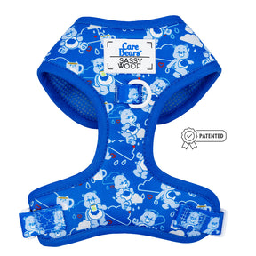 The Dog Adjustable Harness - Care Bears™ Grumpy Bear by Sassy Woof features blue fabric with a white Care Bears pattern, branded on the chest, white trim and hardware, plus a Patented badge on the right.