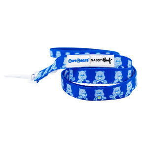 The Sassy Woof Dog Four Piece Bundle - Care Bears™ Grumpy Bear includes a blue leash with smiling Grumpy Bear images and a stitched Care Bears | Sassy Woof label—a perfect match for your Care Bears dog harness.