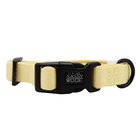 The Sassy Woof Dog Four Piece Bundle - Daffodil features a light yellow adjustable collar with a black plastic buckle, white Sassy Woof branding, and metal D-ring—perfect to pair with your favorite leash or harness.