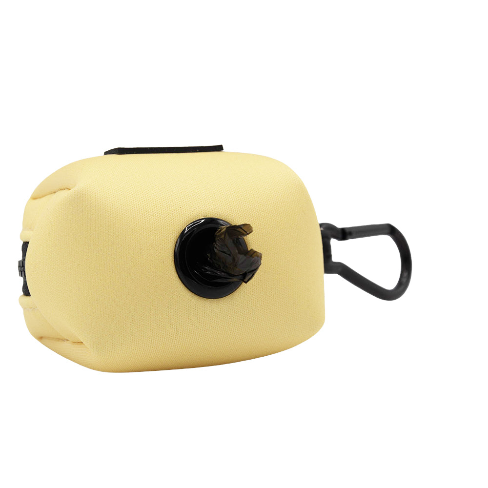 The Sassy Woof Dog Waste Bag Holder - Daffodil is a light yellow, rectangular neoprene holder with a black clip and dispenser opening—perfect for carrying and dispensing pet waste bags on walks.