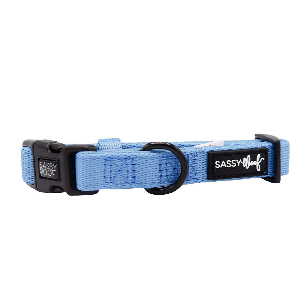 The Sassy Woof Dog Collar - Hydrangea is light blue, features a black plastic buckle, black D-ring, logo tag on the side, and is made from soft neoprene for comfort and durability.