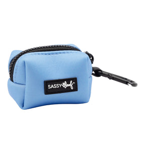 The Sassy Woof Dog Waste Bag Holder - Hydrangea is a small, rectangular light blue pouch with a zipper, black clip, and black Sassy Woof label—ideal for carrying pastel pet accessories in style.