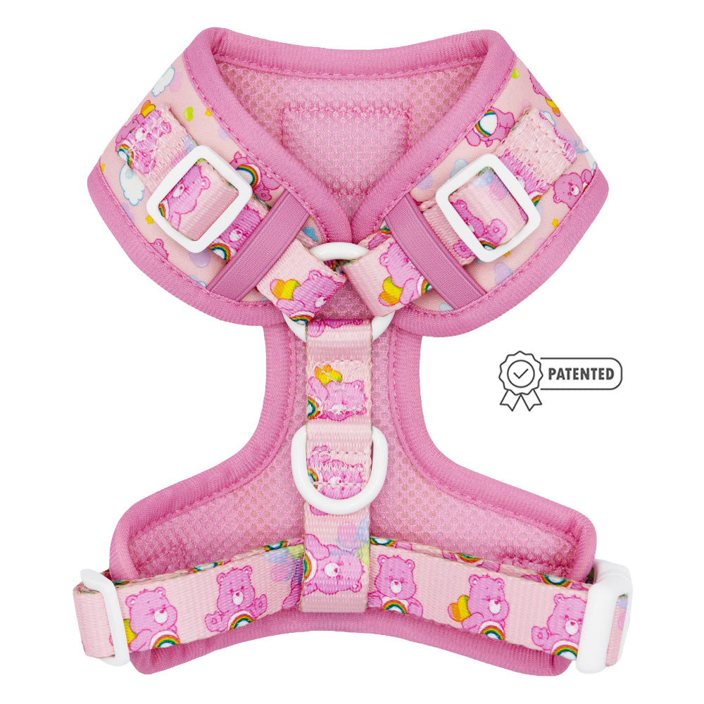 The Sassy Woof Dog Adjustable Harness - Care Bears™ Cheer Bear, in pink with rainbows, hearts, clouds, white buckles, padded mesh, and a PATENTED badge icon, is backed by our Puppy Growth Pawtection Plan.
