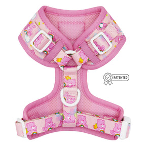 The Sassy Woof Dog Adjustable Harness - Care Bears™ Cheer Bear, in pink with rainbows, hearts, clouds, white buckles, padded mesh, and a PATENTED badge icon, is backed by our Puppy Growth Pawtection Plan.