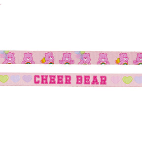 Sassy Woof’s Dog Leash - Care Bears™ Cheer Bear features pink ribbon with repeating Cheer Bear, rainbows, hearts, and balloons. CHEER BEAR is in bold pink letters with pastel hearts—perfect for a cute Care Bears dog harness look.