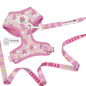 The Sassy Woof Dog Two Piece Bundle - Care Bears™ Cheer Bear includes an adjustable harness with Cheer Bear and heart designs, a Sassy Woof label, and a matching leash reading CHEER BEAR in bold pink plus a patented badge icon.