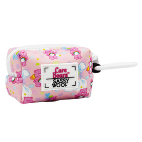 The Sassy Woof Dog Waste Bag Holder – Care Bears™ Cheer Bear is a small pink rectangular pouch with rainbow Care Bears designs, a white zipper, and black-and-white clip—perfect for pairing with your favorite Care Bears harness.