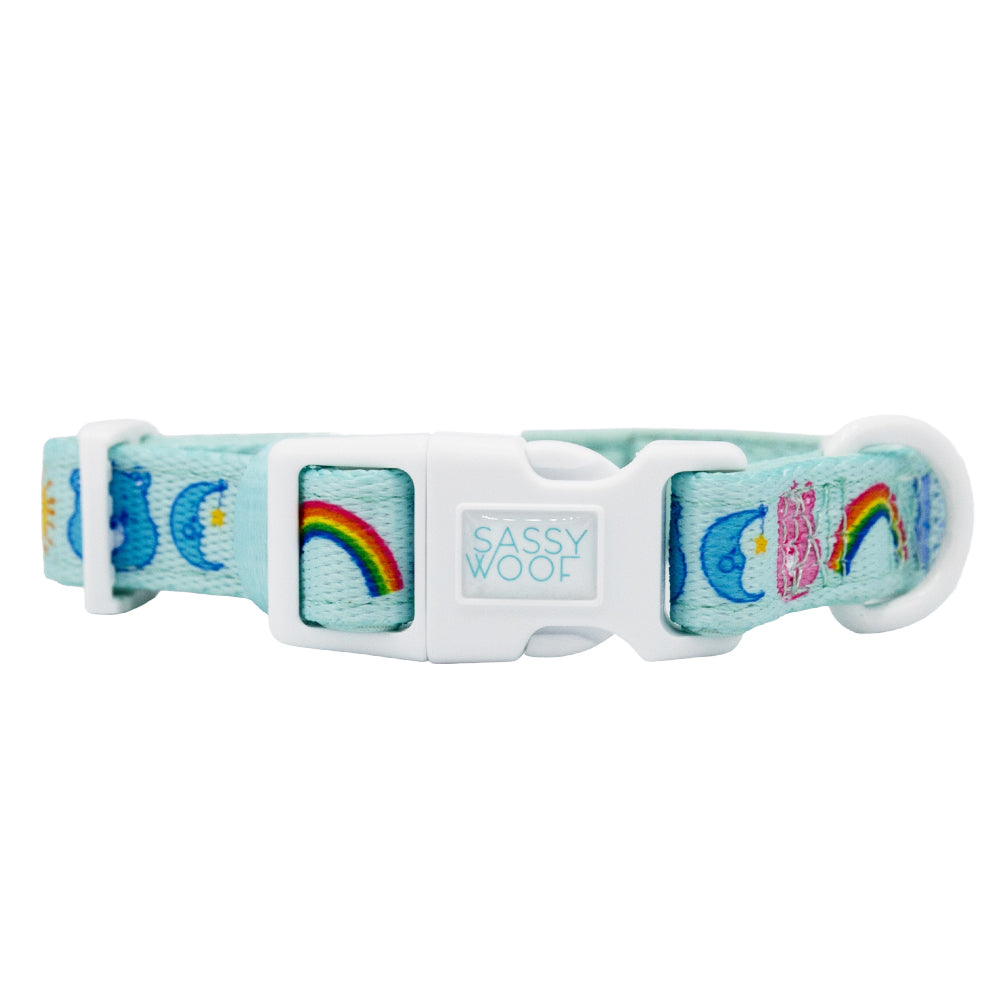 The Collar Three Piece Bundle - Care Bears™ Care-a-Lot by Sassy Woof features a light blue strap with rainbows, clouds, and sun designs plus a white buckle—perfect for fans of nostalgic pet accessories and the Care Bears collection.