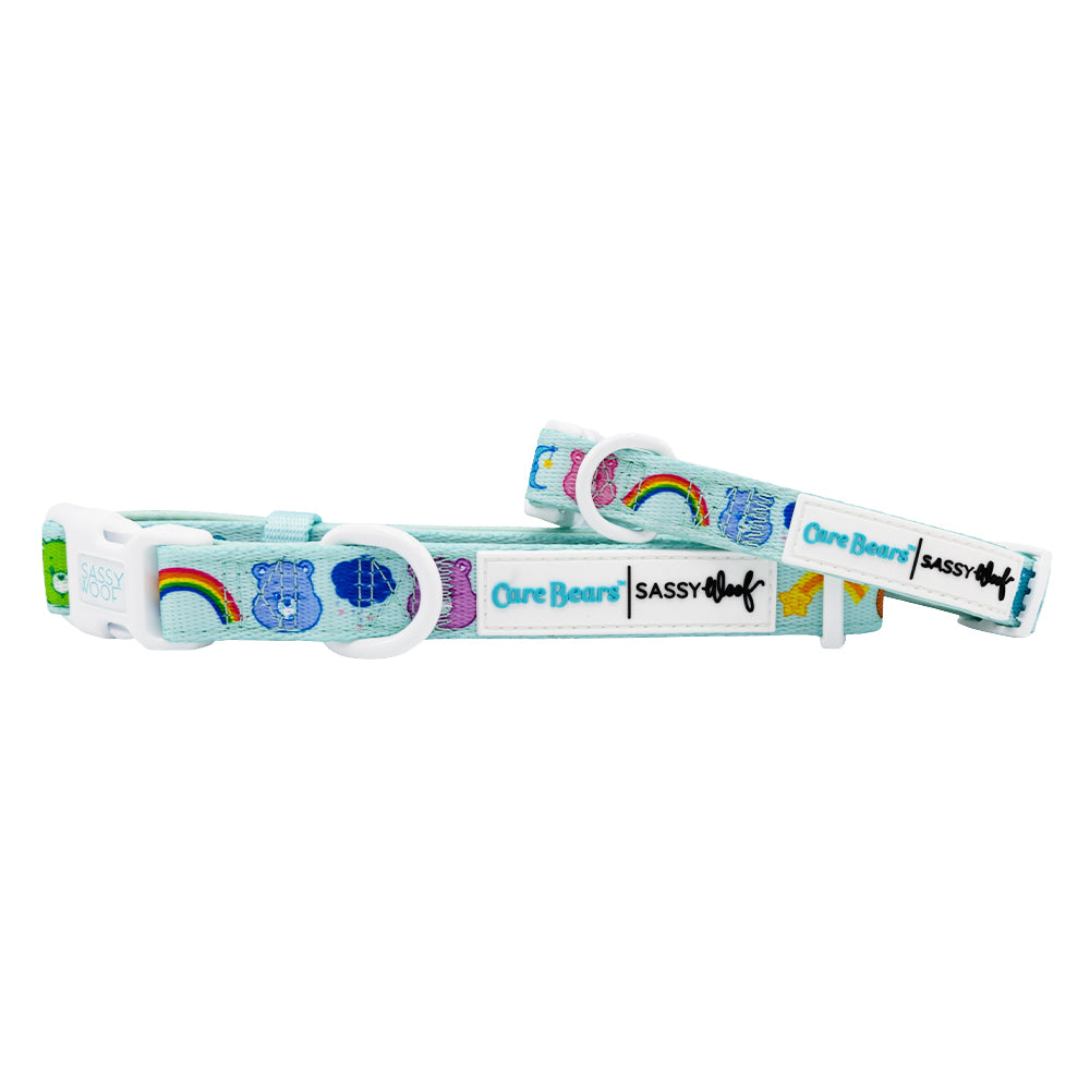 Two light blue Dog Collar - Care Bears™ Care-a-Lot by Sassy Woof, featuring rainbows and logos. Each adjustable neoprene collar has white plastic buckles and easy adjustment slides.
