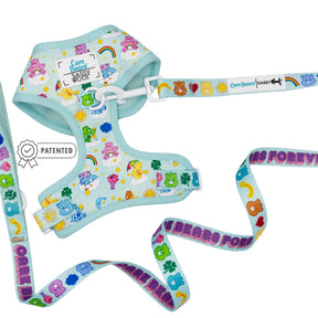 The Sassy Woof Dog Two Piece Bundle - Care Bears™ Care-a-Lot features a pastel blue harness and adjustable leash with Care Bears, rainbows, hearts, and flowers. The harness has logo tags; the leash reads "CARE BEARS FOREVER.