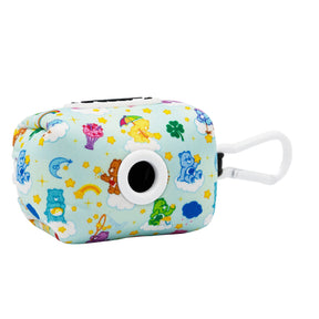 The Sassy Woof Collar Three Piece Bundle - Care Bears™ Care-a-Lot is a light blue, rectangular dog waste bag holder with cute bears, clouds, stars, and rainbows, plus a black dispenser ring and white clip for your dog's collar or leash.