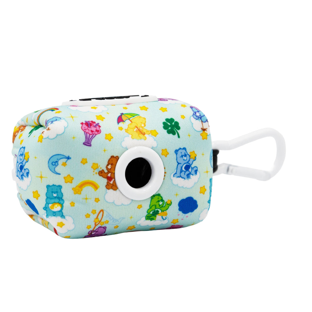 The Sassy Woof Dog Waste Bag Holder - Care Bears™ Care-a-Lot is a small, rectangular, light blue fabric holder with a white clip and black circular opening, featuring colorful Care Bears, stars, clouds, rainbows, and hearts.