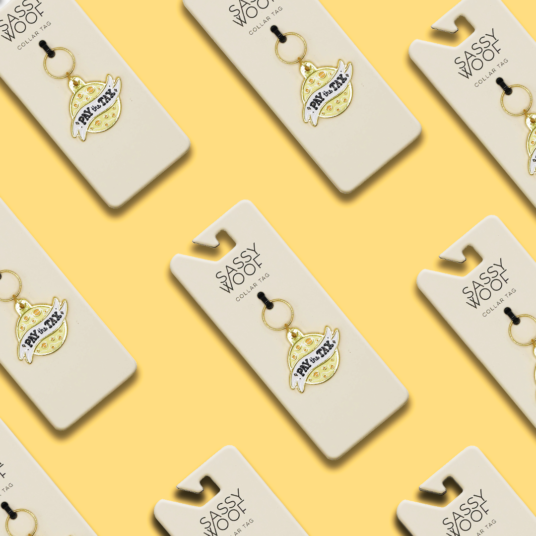 A repeating pattern of Sassy Woof keychains on beige cards, each featuring the Collar Tag - Cheese Tax, set against a yellow background.