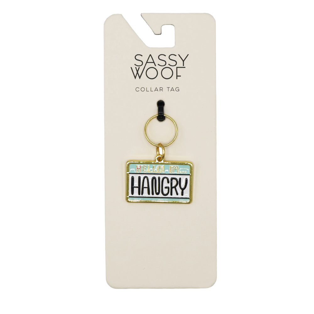 The Sassy Woof Collar Tag - Hello I'm Hangry is a license plate-style rectangular pet tag on a branded backing card, boldly declaring HELLO IM HANGRY in black—ideal for dogs with attitude!.