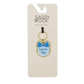 The Sassy Woof Collar Tag - Mama's Boy is a cat-shaped dog tag with a blue bow and "mamas boy" text, attached to a card featuring the Sassy Woof brand name at the top.