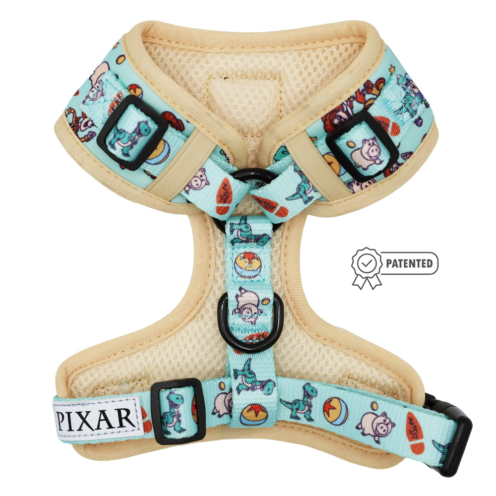 The Sassy Woof Dog Adjustable Harness—Disney and Pixar's Toy Story—features light blue fabric with tan trim, playful Buzz Lightyear and Woody illustrations, a PIXAR label, PATENTED badge, and supports the Puppy Growth Pawtection Plan.