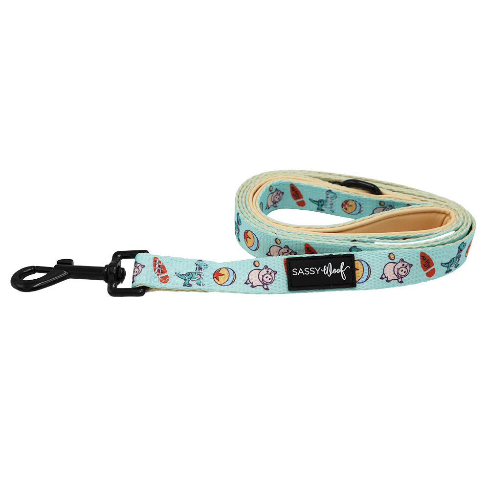 The Sassy Woof Dog Leash - Disney and Pixar's Toy Story features playful dog, bone, and tennis ball prints in light blue with a black metal clip and branded tag—ideal for fans of Disney dog accessories.