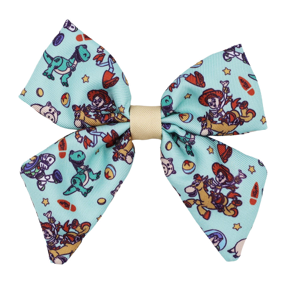 The Sassy Woof Dog Sailor Bow - Disney and Pixar's Toy Story features Woody, Jessie, Bullseye, Rex, stars, and toys on light blue fabric with a beige center—perfect for your pup at the dog park.