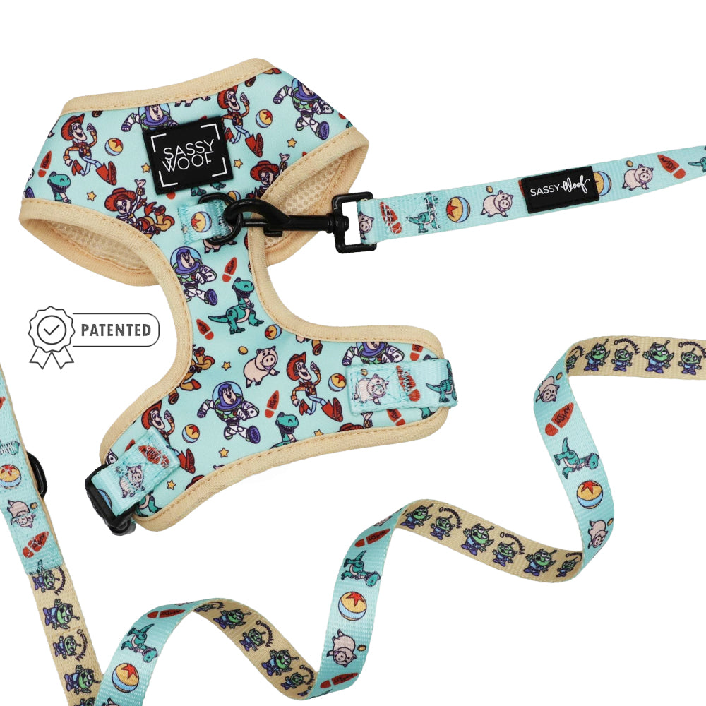 The Dog Two Piece Bundle - Disney and Pixar's Toy Story by Sassy Woof features a light blue adjustable harness with a Sassy Woof label and Patented badge, plus a matching leash with playful cartoon animal and beach-themed prints.